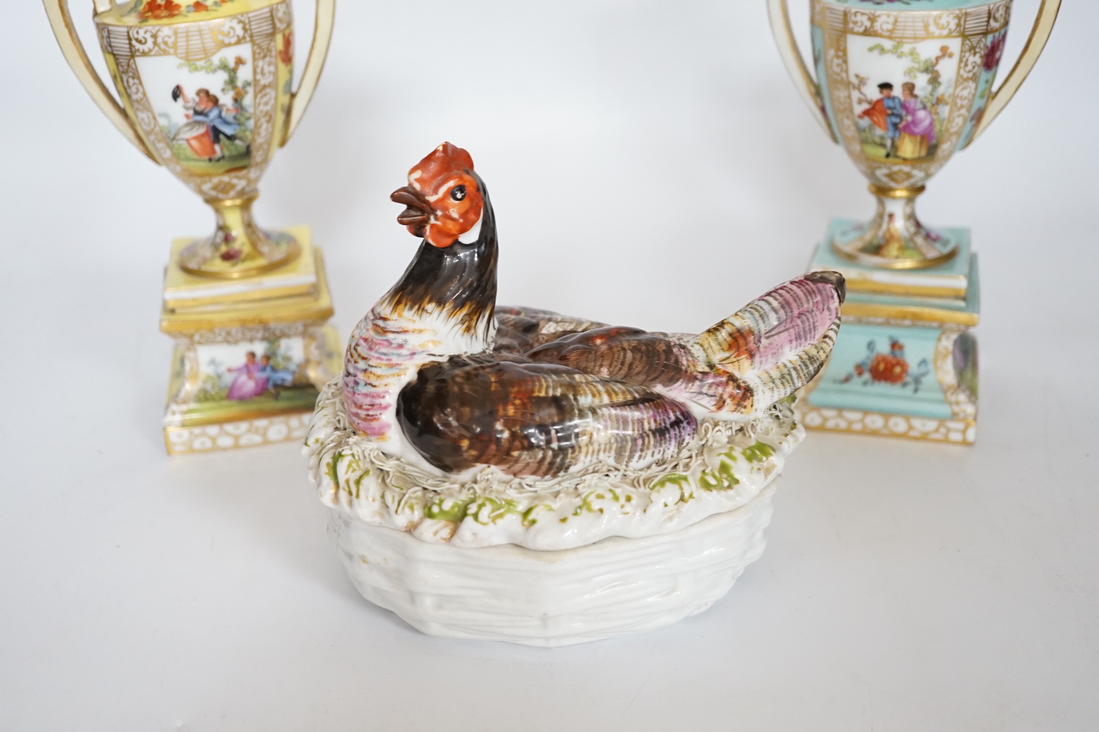 A pair of Dresden porcelain vases and covers (restored) together with a hen egg basket and cover, largest 19cm high (3)